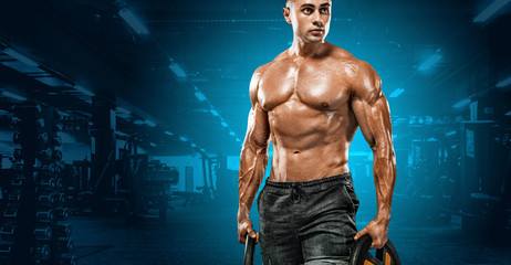 Fitness man warming up in gym. Strong muscular bodybuilder athlete. Bodybuilding and sport concept. Copy space for sport nutrition ads.