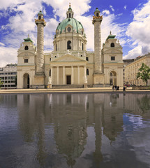 Fototapeta na wymiar Karlskirche St. Charles’ Church with reflections into the water in Vienna, Austria