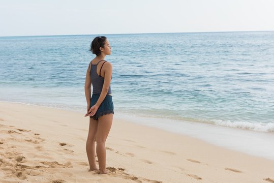 Woman standing with eyes closed in the beach