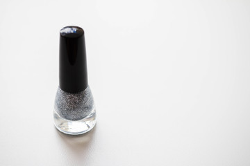 silver nail polish on white background