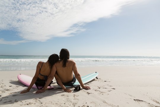 Surfer Couple Relaxing In The Beach