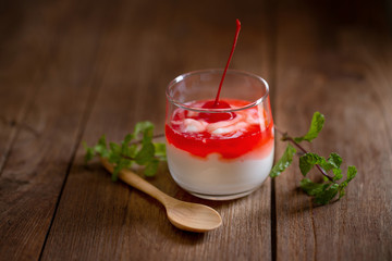 Glass of Cherry yogurt on a brown wood table