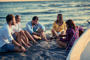 group of young friends with guitar having fun on the beach.