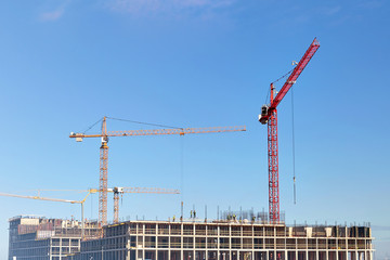 Construction cranes , construction on blue sky background.