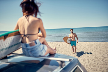 Obraz premium Sporty people with surf boards on the beach - Extreme sport and vacation concept.