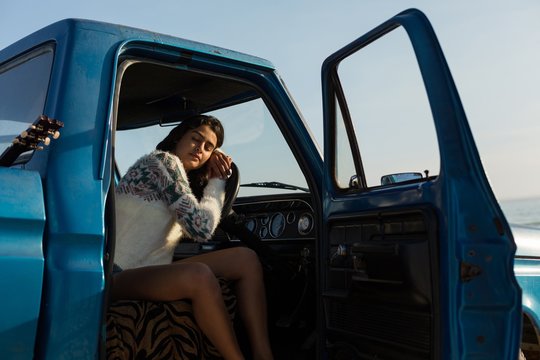 Young woman sleeping in pickup truck