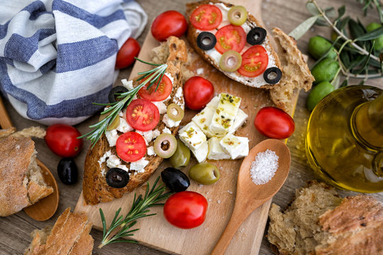 top view Italian bruschetta with tomatoes, mozzarella cheese, olives and fresh vegetables.
