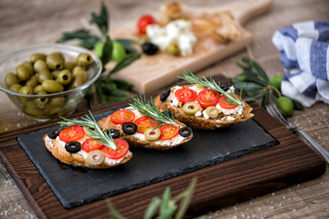 Italian sandwich- bruschetta with tomatoes, mozzarella cheese, olives and fresh vegetables. - obrazy, fototapety, plakaty