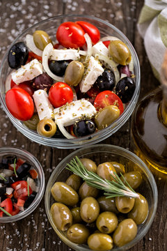 Greek salad with fresh vegetables, feta cheese and green olives top view.
