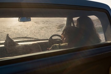 Couple relaxing in a pickup truck at beach
