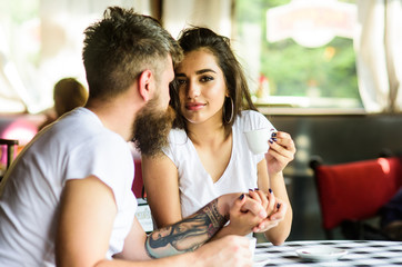 Share romantic feelings with cup of coffee. Man with beard and attractive happy smiling girl drinking coffee. Couple in love drink black espresso coffee in cafe. Couple happy spend time in cafe