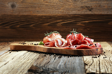 Food tray with delicious salami, ham,  fresh sausages and herbs. Meat platter with selection
