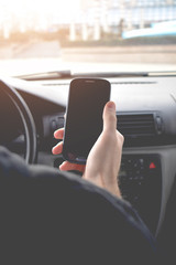Businessman driving a car. Man with smartphone in the car