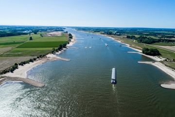 aerial view commercial ship crossing the River Rhine in an area of the Netherlands