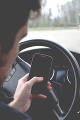 Businessman driving a car. Man with smartphone in the car