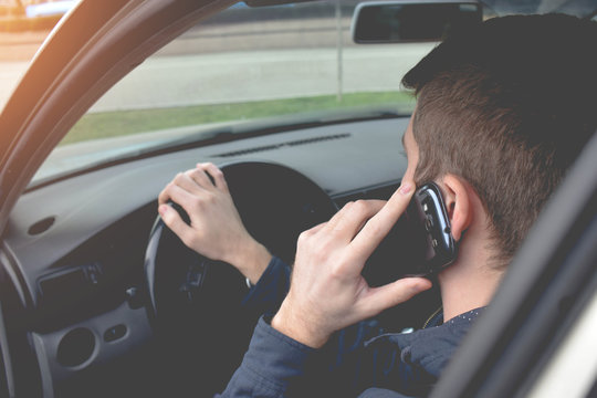 Handsome Man Using Smartphone While Driving The Car