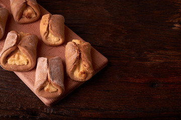 Homemade buns stuffed with cottage cheese on a wooden background. Macro photo. Selective focus.