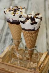 Ice cream cornetto.  Ice cream waffle cone vanilla and chocolate on rustic background