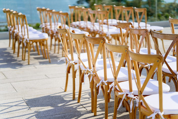 Selective focus of wooden folding lawn chairs line up for outdoors wedding venue