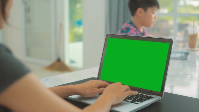 Woman working at home on with laptop green screen