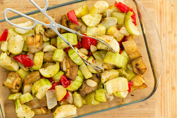 Overhead view of healthy vegetable dish with tongs