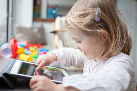 Female toddler playing on a tablet