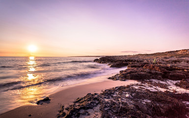 Early morning sunset at a pristine and golden coast watercolor beach of Formentera Island in the mediterranean sea, Balearic Island, in front of Ibiza Island. Unesco World Heritage site. 