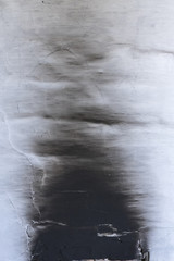 White oven wall in black soot, charred mark. Exiting the door hole, filled with brick
