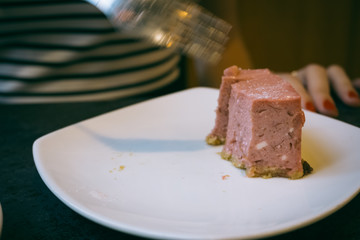 Close-up of a stone table with a cup of coffee and a delicious piece of cake. Model cuts the cheesecake with a fork. Fashionable new interior. Perfect background for websites or coffee shops
