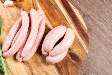 Uncooked pork sausages on chopping board