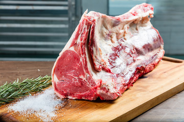 Raw whole beef T bone on chopping board