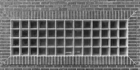 Black and White image of glass building blocks in a brick wall
