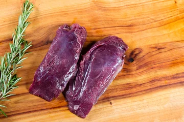 Fototapeten Raw kangaroo meat slices on chopping board © Zstock