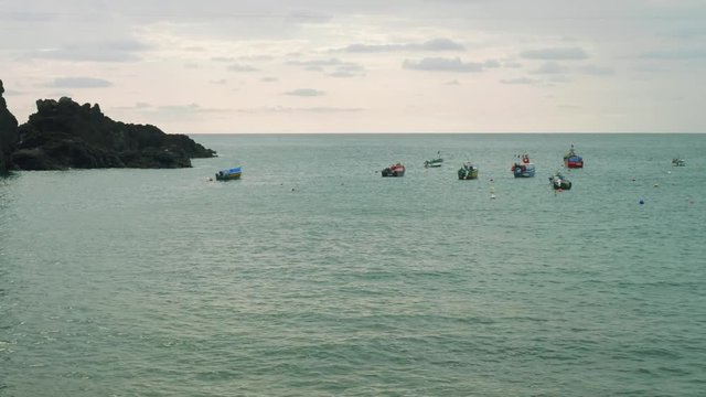 View of anchored yachts and boats swing in inlet of village Camara de Lobos