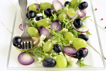Salad with various grapes, goat cheese, purple onion, arugula