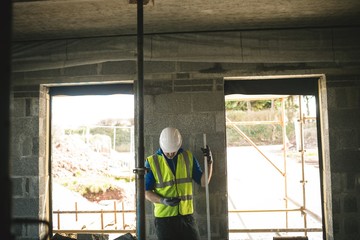 Engineer with level gauge using his phone