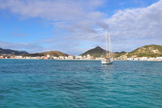 Sailboat on the ocean with a tropical island in the background