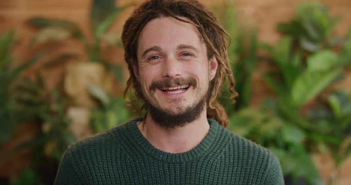 portrait of cute young man smiling enjoying success lifestyle satisfaction caucasian male with dreadlocks hairstyle slow motion