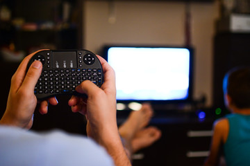 The mini black keyboard in the living room is used for the use of various interesting content, connecting the device in the afternoon relaxing atmosphere in the home.