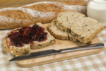 Morning easy breakfast, bread, jam , and cornflakes on wooden background