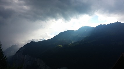 Fototapeta na wymiar Stimmunugsvolle Szene mit Wolken und Sonne in den schweizer Alpen