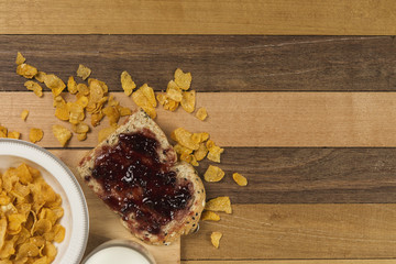 Morning easy breakfast, bread, jam , and cornflakes on wooden background
