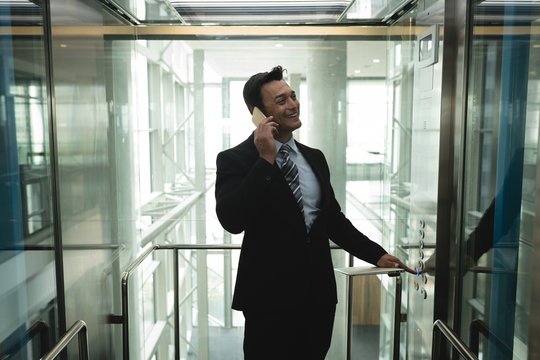 Businessman talking on the phone in elevator 