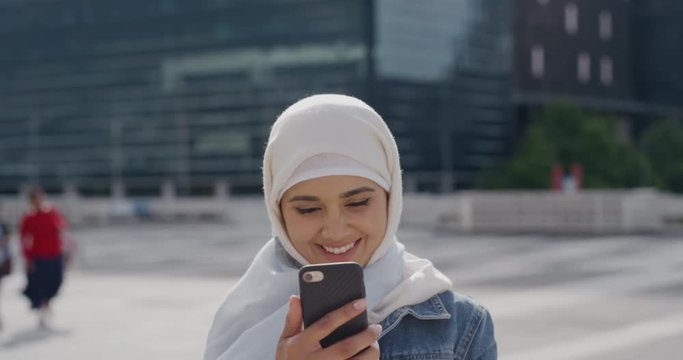 portrait beautiful young muslim woman tourist using smartphone taking selfie photo posing happy in city enjoying urban travel sharing experience wearing hijab headscarf slow motion