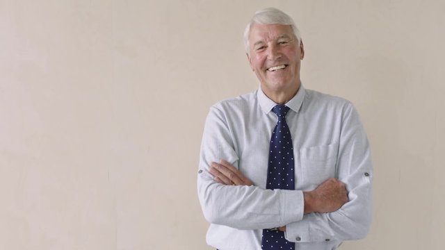 portrait of elderly entrepreneur laughing arms crossed retirement