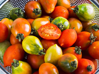 Italian tomatoes in a colander on table. Cooking with tomatoes concept. Local organic vegetables