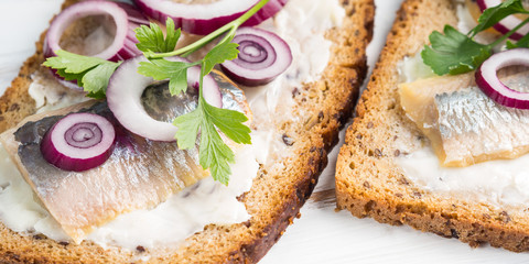 Danish open sandwich smorrebrod with salted herrings, red onion, butter. Traditional snack