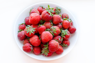 white plate with fresh strawberries on white background. horizontal orientation.strawberry close-up, isolated.