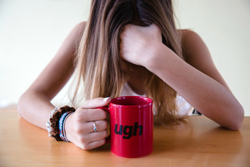 Female with a coffee mug that says ugh