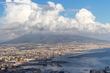 Naples and port of Mediterranean sea and volcano Vesuvius top view. Naples cityscape. Volcano Vesuvius in clouds. Volcano and sea landscape. Travel concept. Aerial italian landscape. Neapol panorama. 